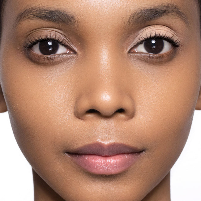 Close-up of a woman's face wearing color tan eye base