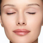 Close-up of a woman's face wearing demure eye base essential
