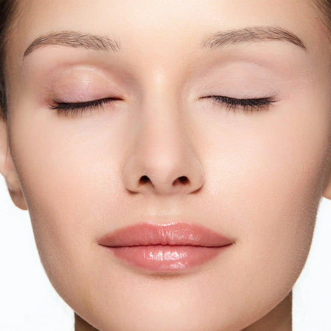 Close-up of a woman's face wearing demure eye base essential