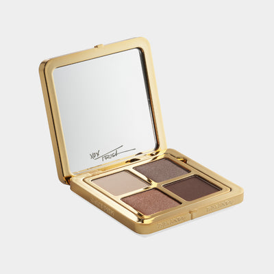 Makeup palette with four shades in a gold case on a light gray background
