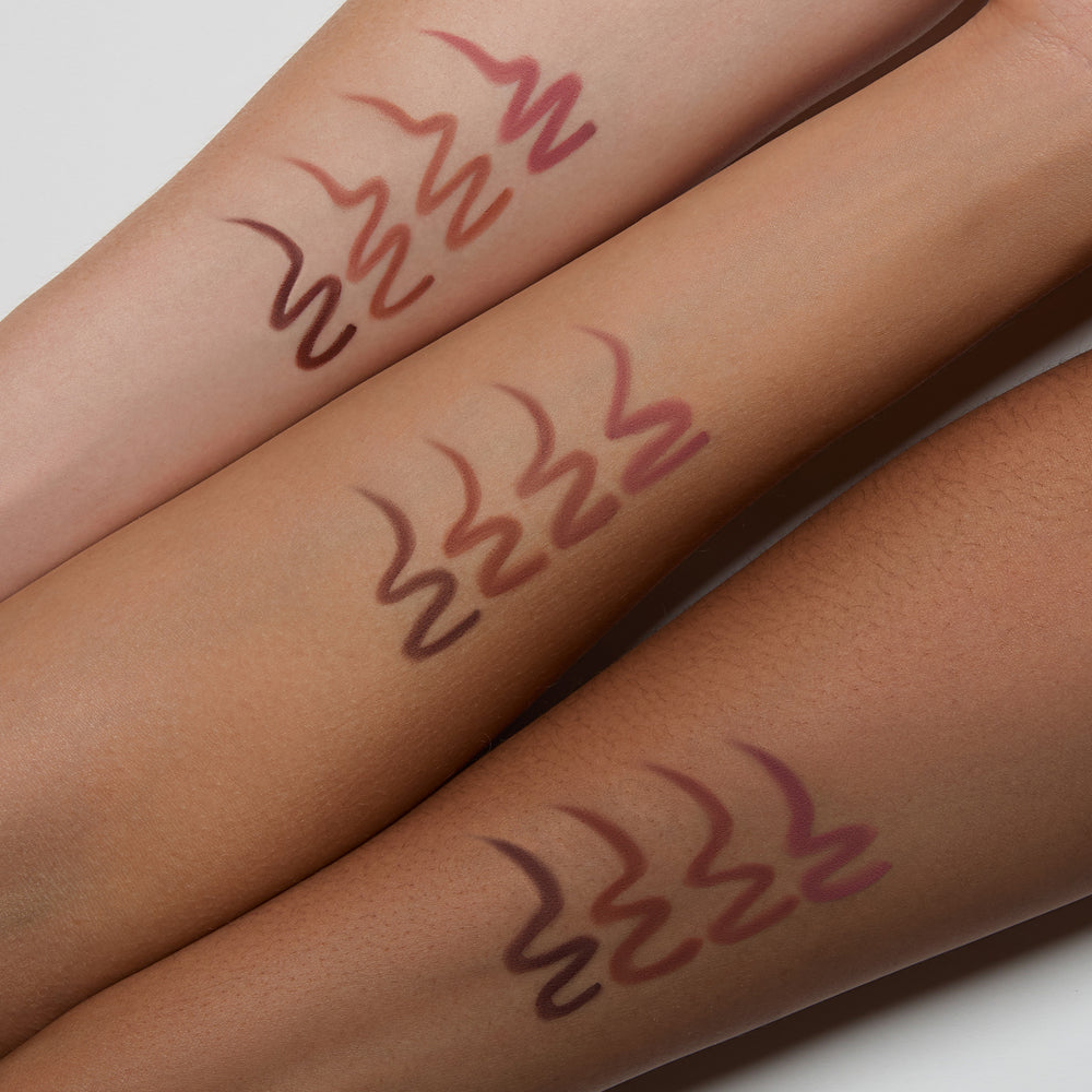 Three swatches of a lipstick on different skin tones