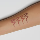 Lipstick swatch on a person's arm with a white background