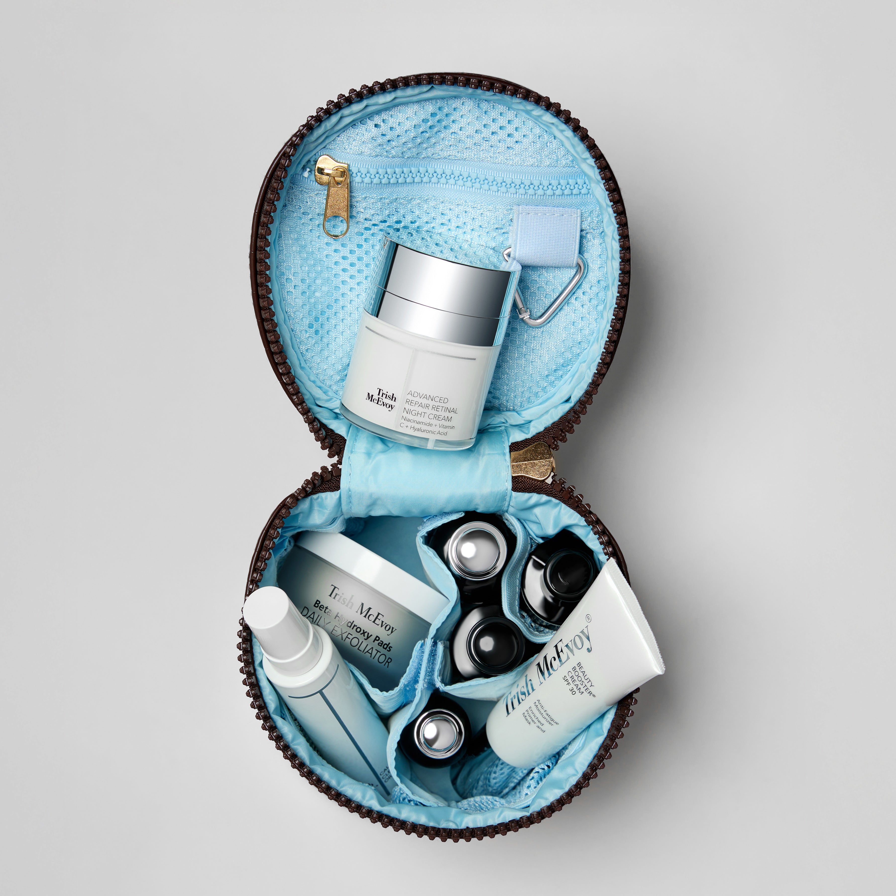 Open cosmetic bag with skincare products on a light gray background