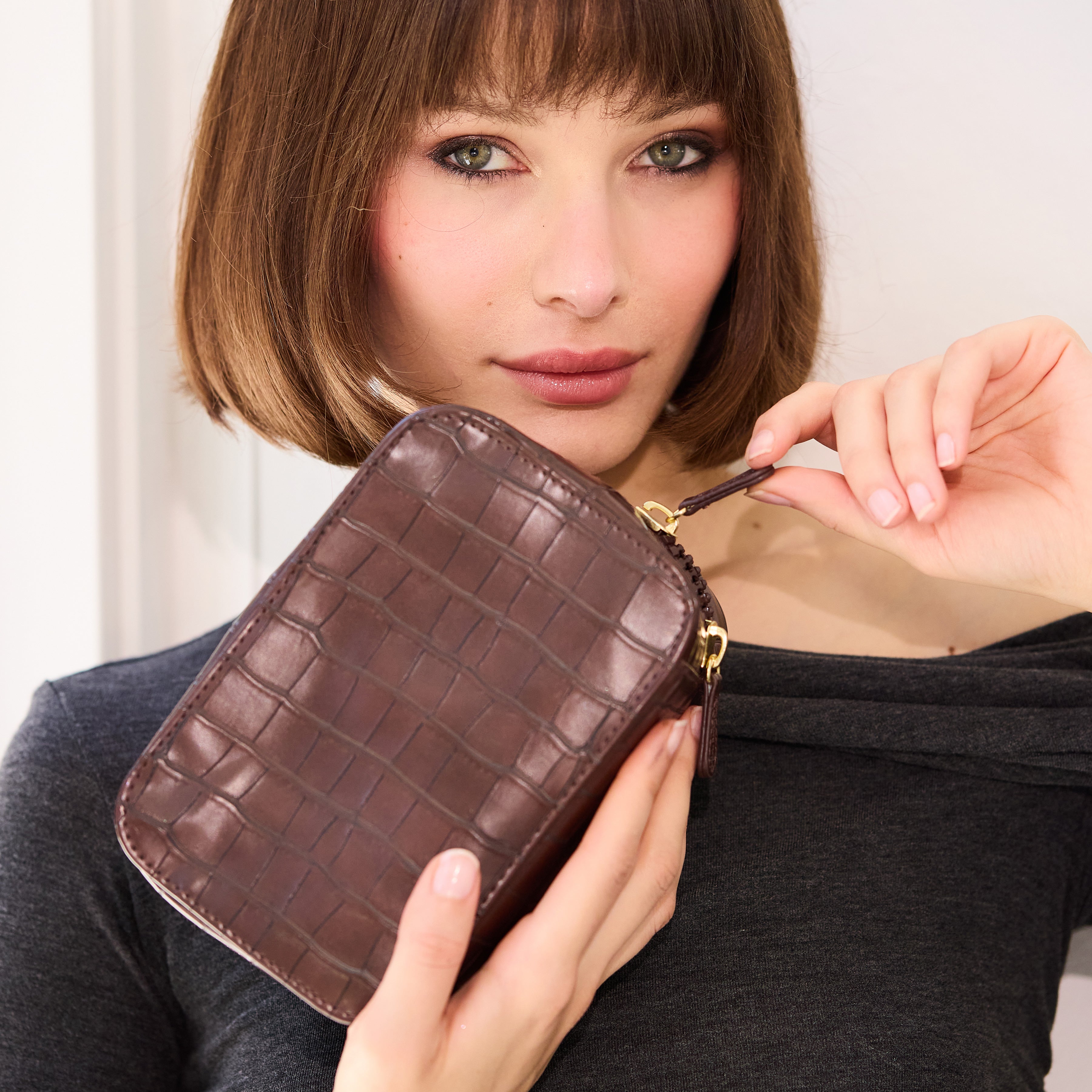Woman holding a brown crocodile-patterned planner