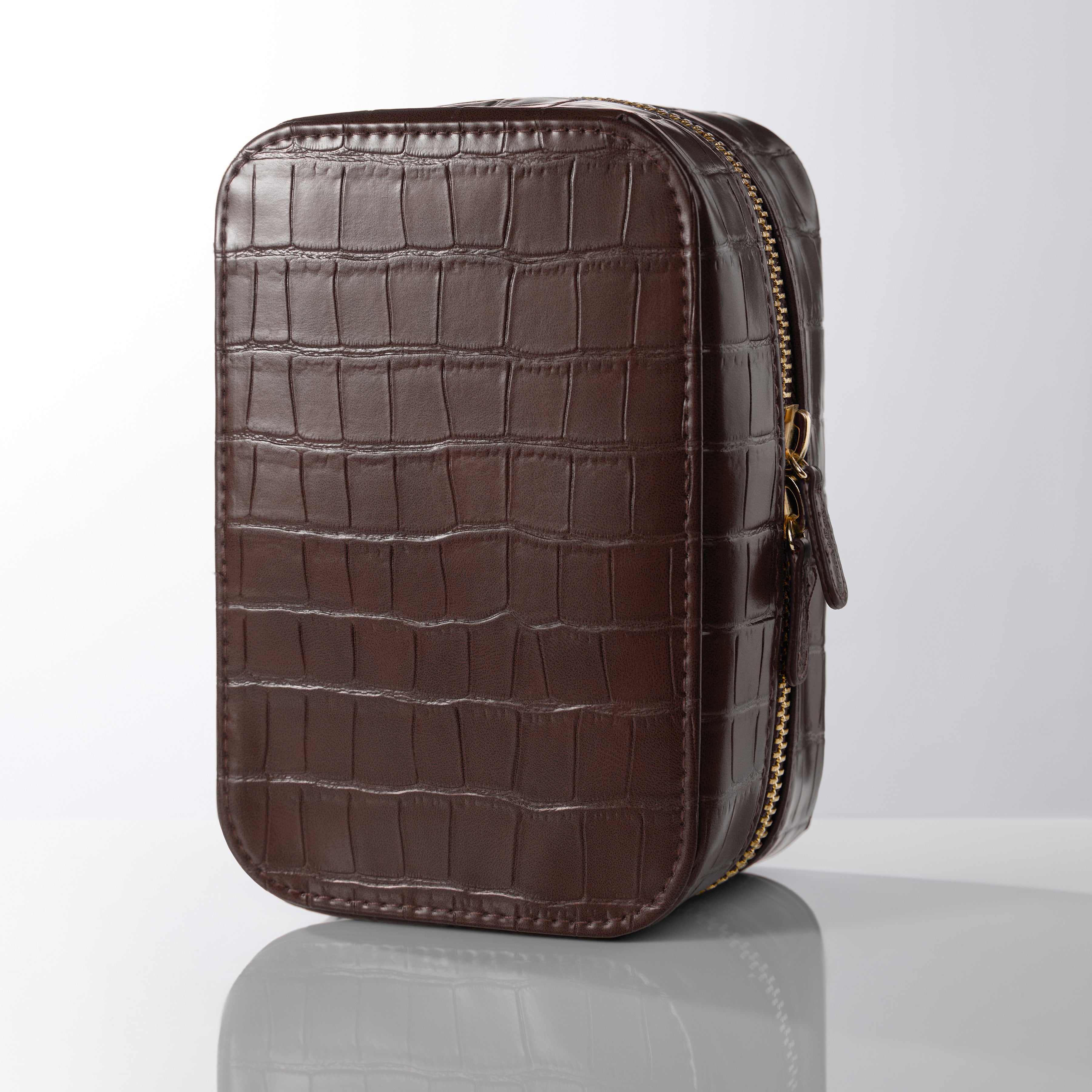 Brown crocodile-patterned leather pouch with a gold zipper on a white background