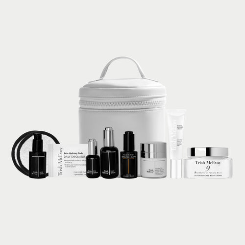 Trish McEvoy skincare products including bottles, jars, and a white travel case on a white background.