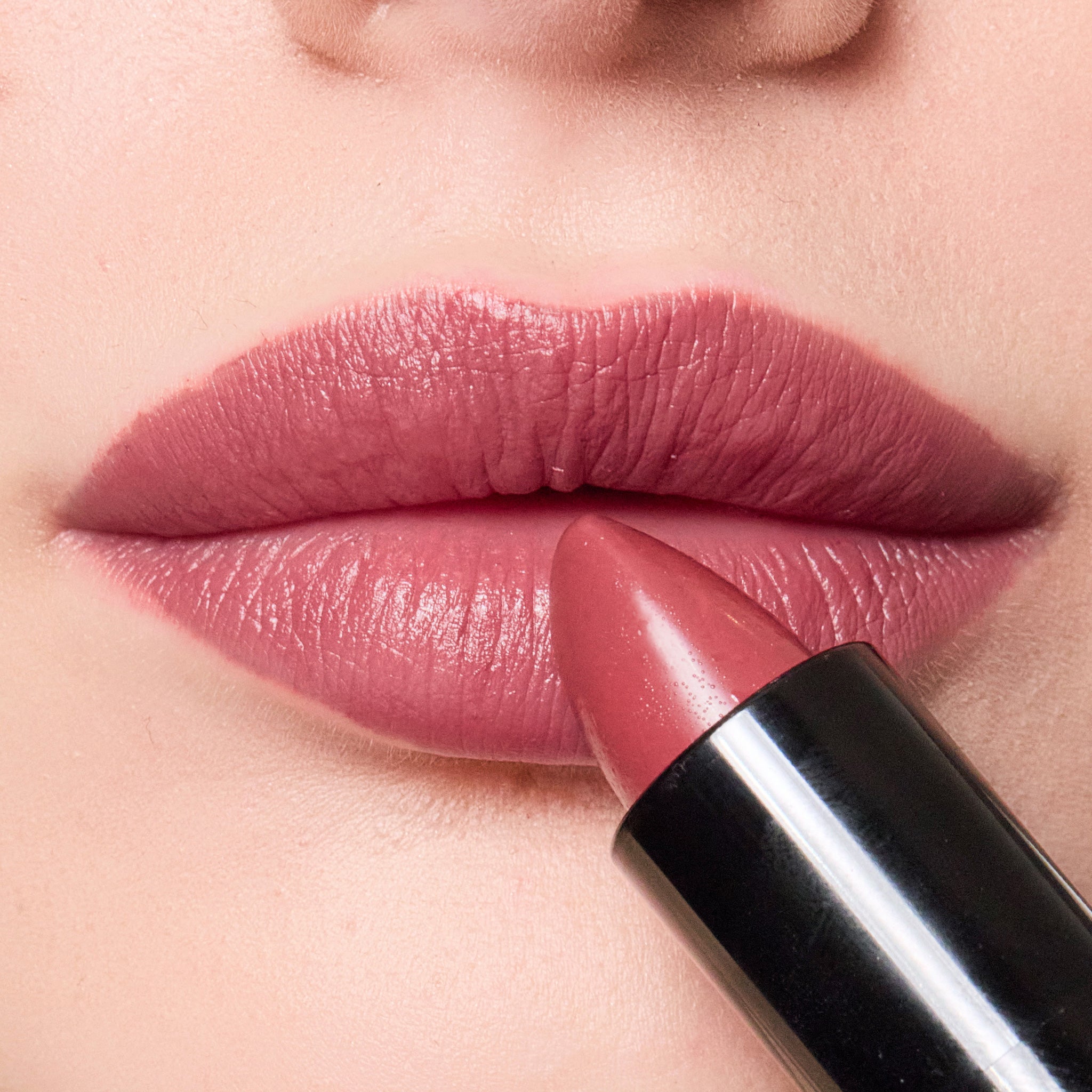 Close-up of color merlot lipstick being applied to lips.