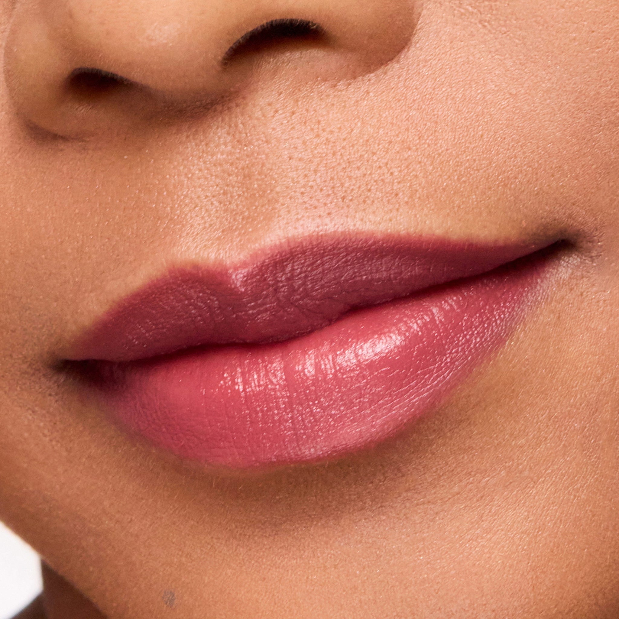 Close-up of a person's lips wearing color merlot pink lipstick.