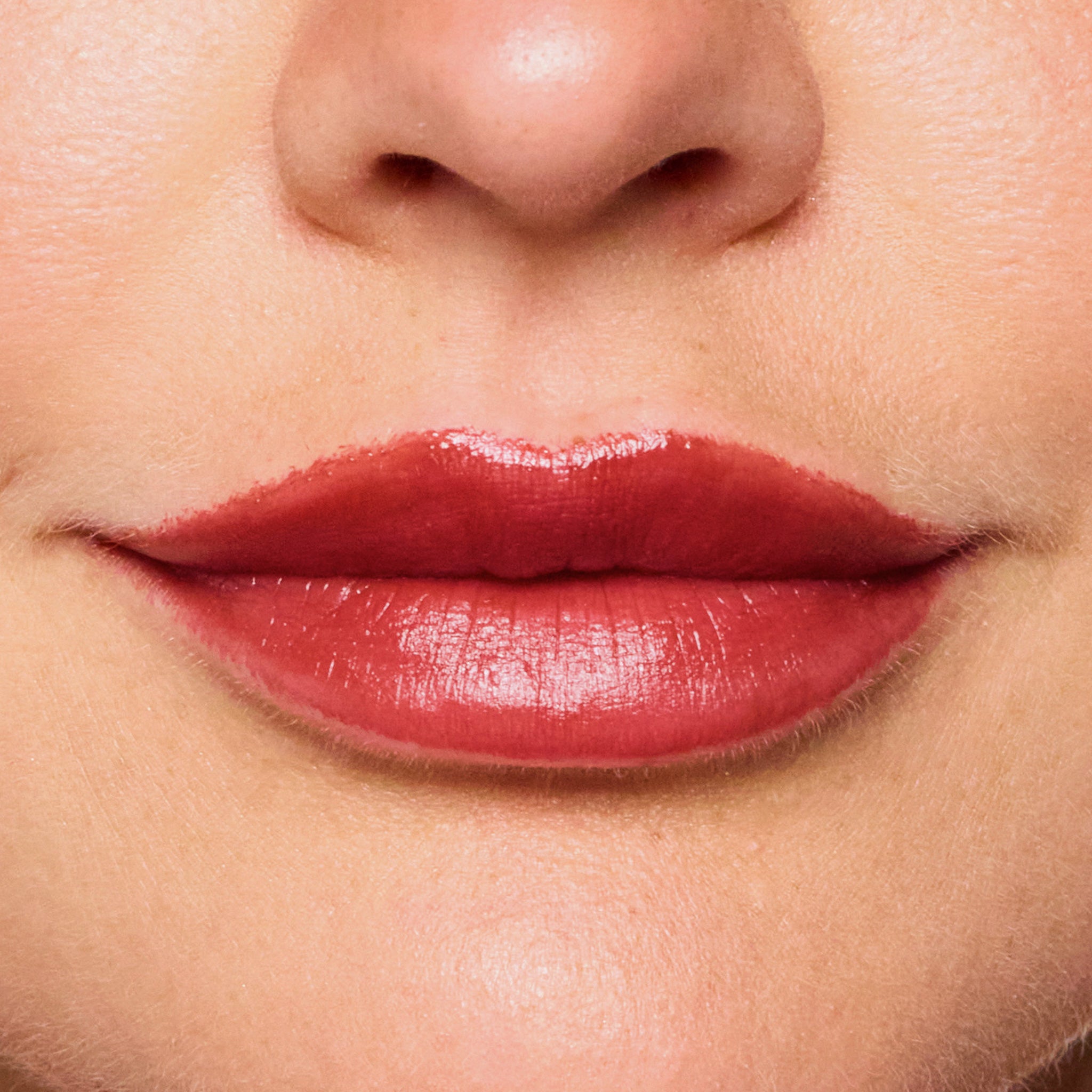 Close-up of a woman's lips with color bordeaux lipstick on a neutral background