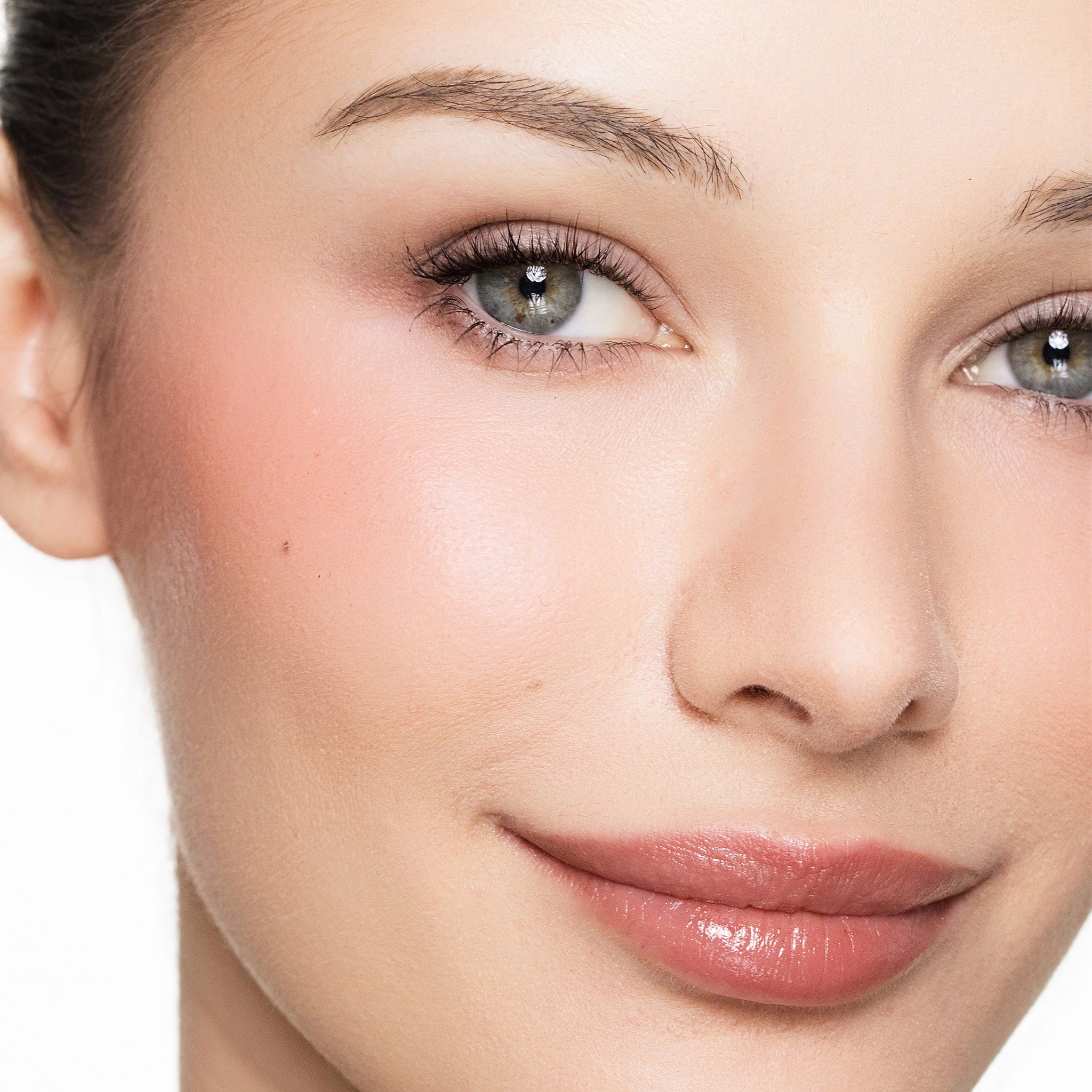 Close-up of a woman's face wearing color brighten blush