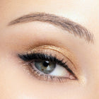 Close-up of a woman's eye with color gold eye makeup