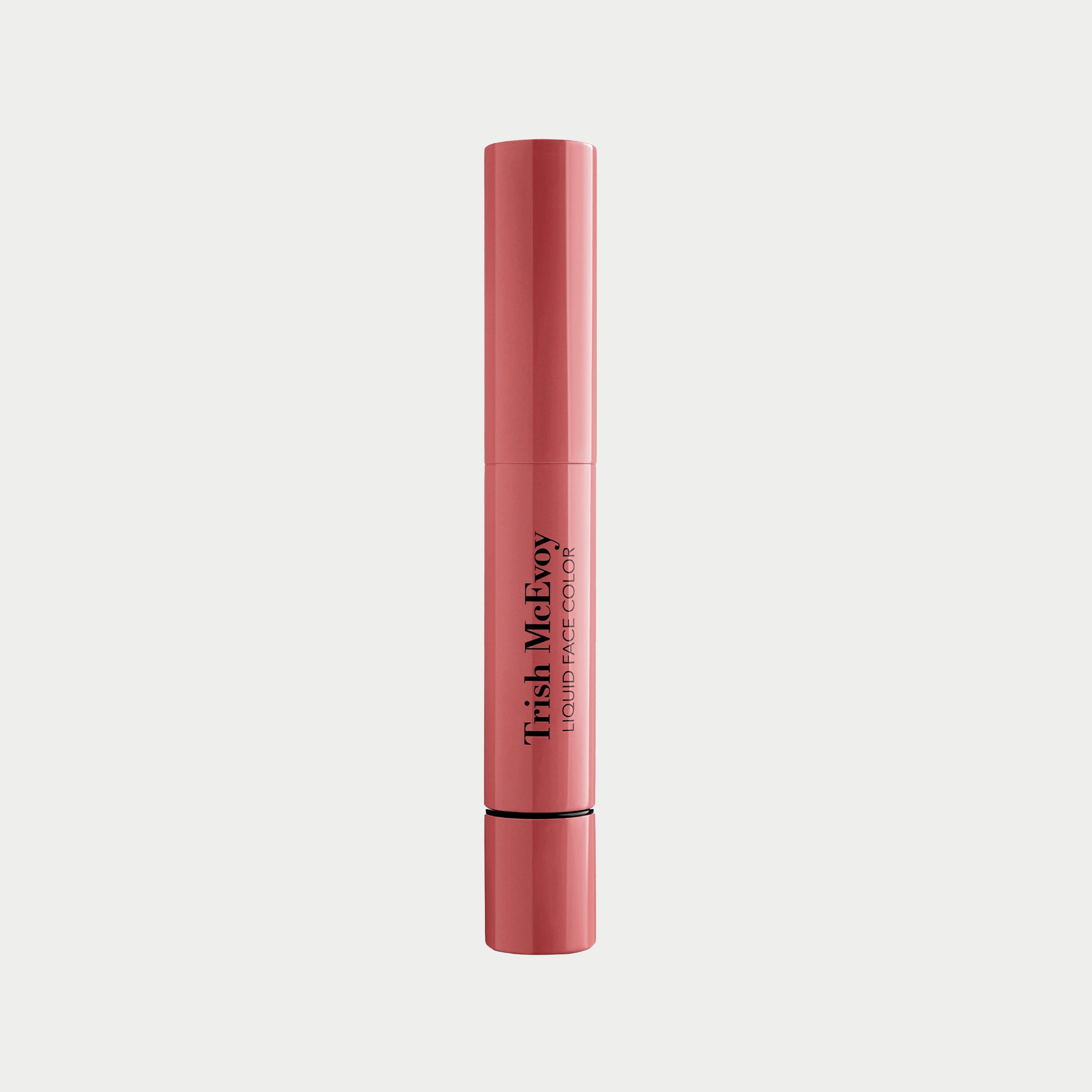 Pink liquid face color pinched tube with 'Trish McEvoy' branding on a light gray background