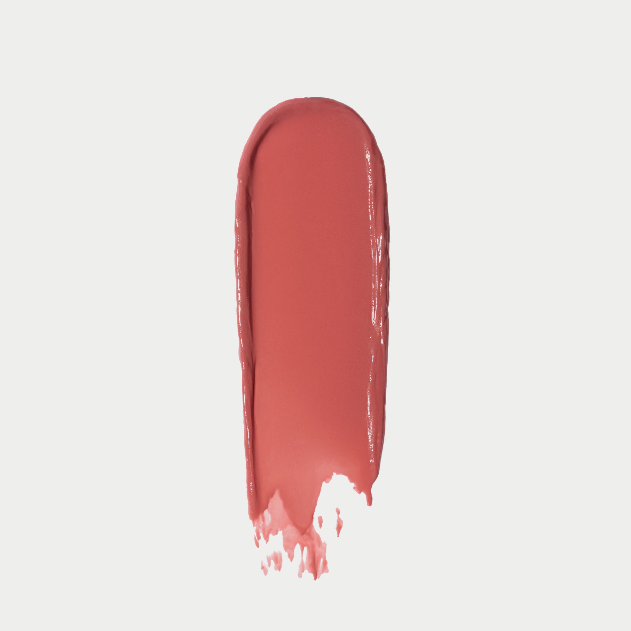 Coral-toned lip balm swatch showing sheer, glossy finish with streaked application pattern.