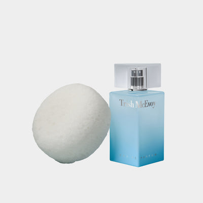 Blue Trish McEvoy no. 8 perfume bottle next to a sexy 9 sponge on a white background