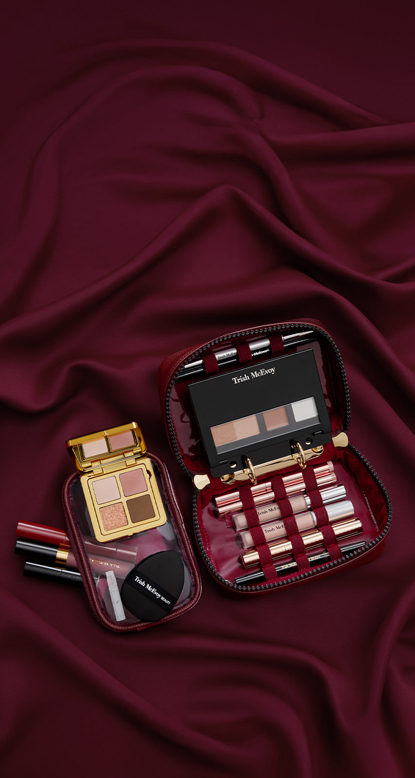 Makeup set with lipsticks and palettes on a burgundy fabric background